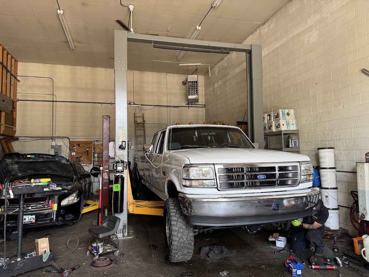 Multiple vehicles on lifts inside the shop